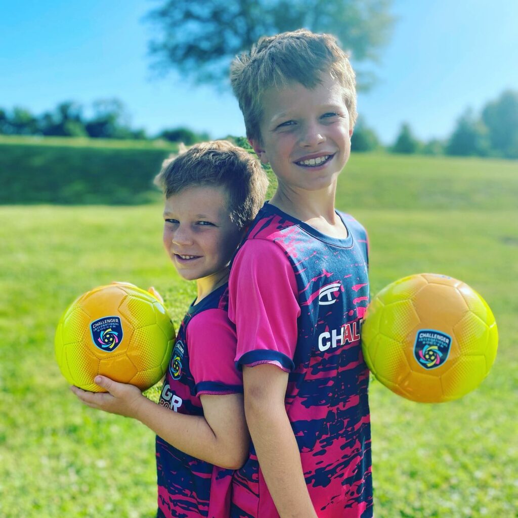 Young players posing with their soccer balls