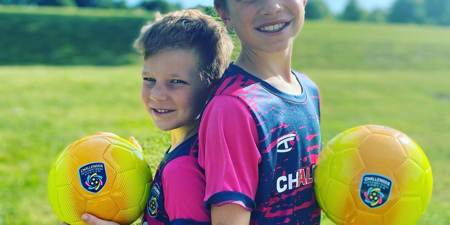 Young players posing with their soccer balls