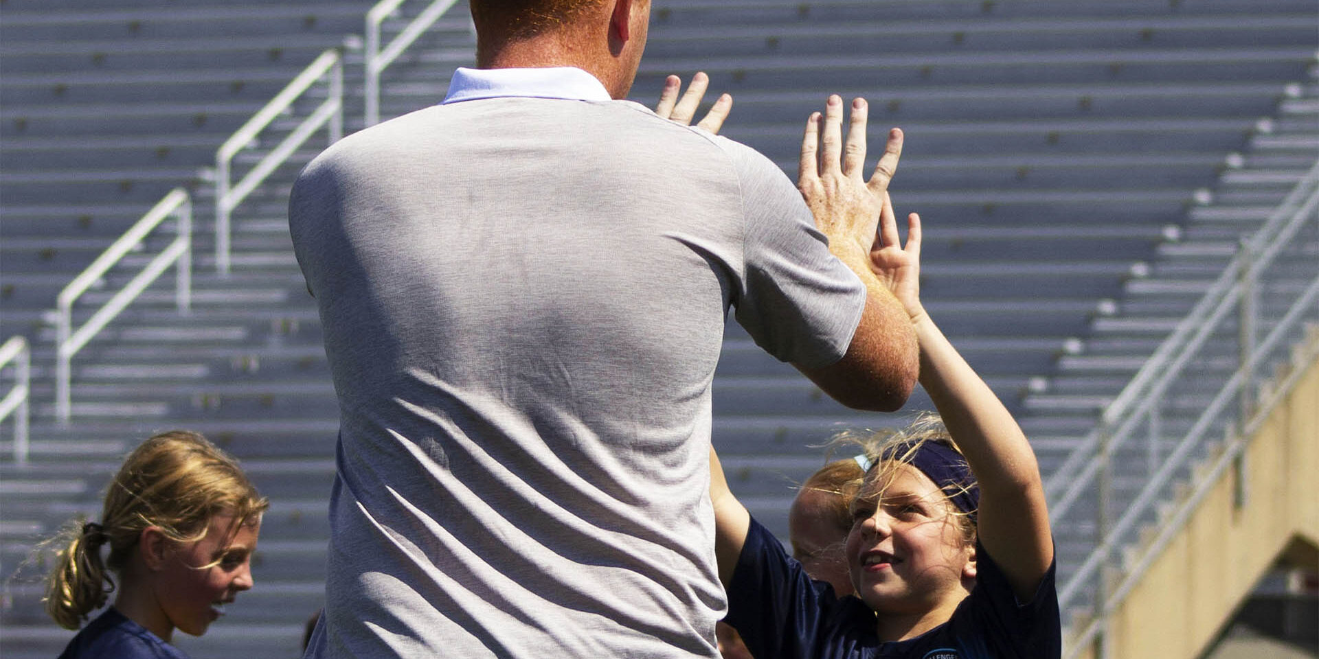 Coach giving children a double high five