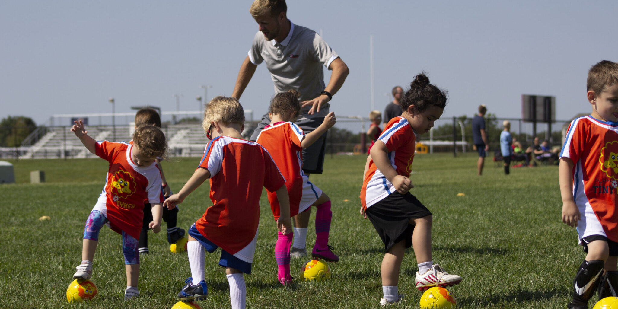 TinyTykes young players learning fundamental skills with coaches on camp