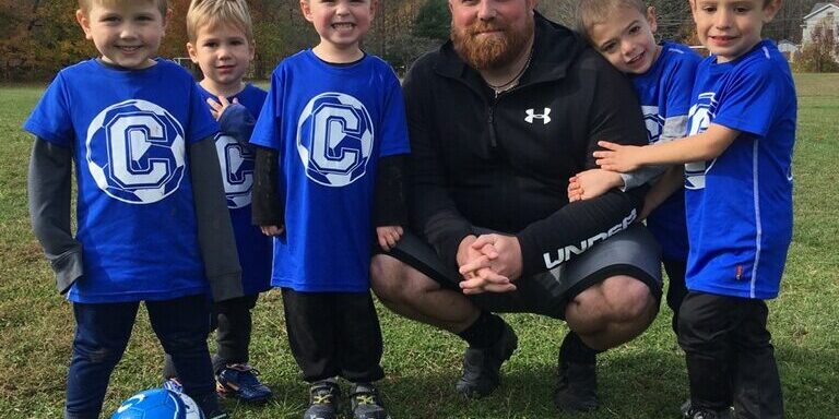 Young players pose with coach on camp
