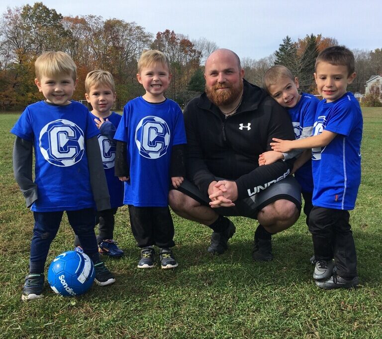 Young players pose with coach on camp