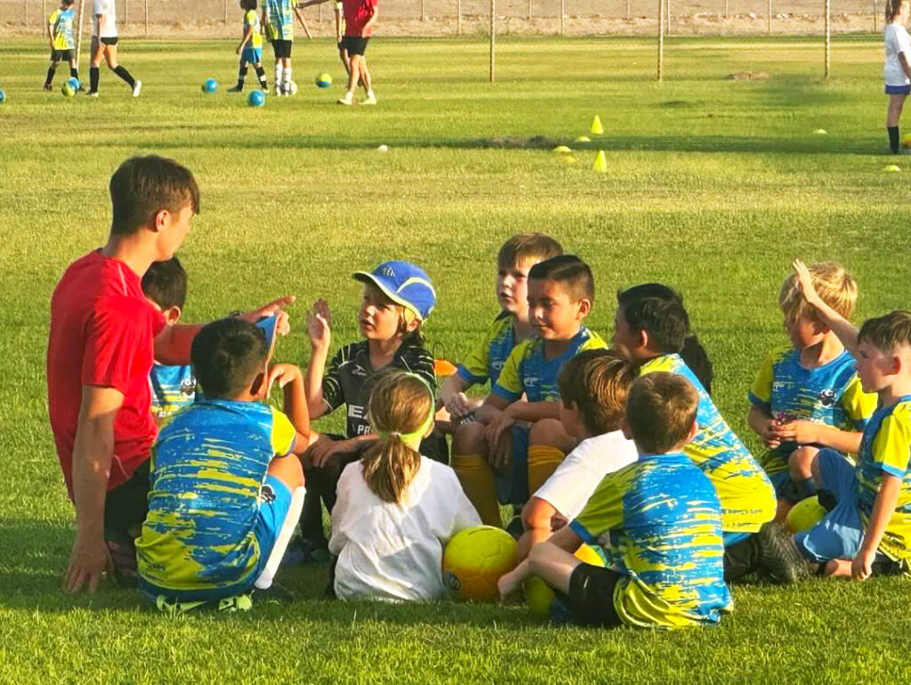 Kids talking with coaches on camp asking questions