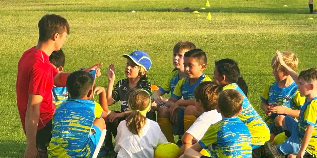 Kids talking with coaches on camp asking questions